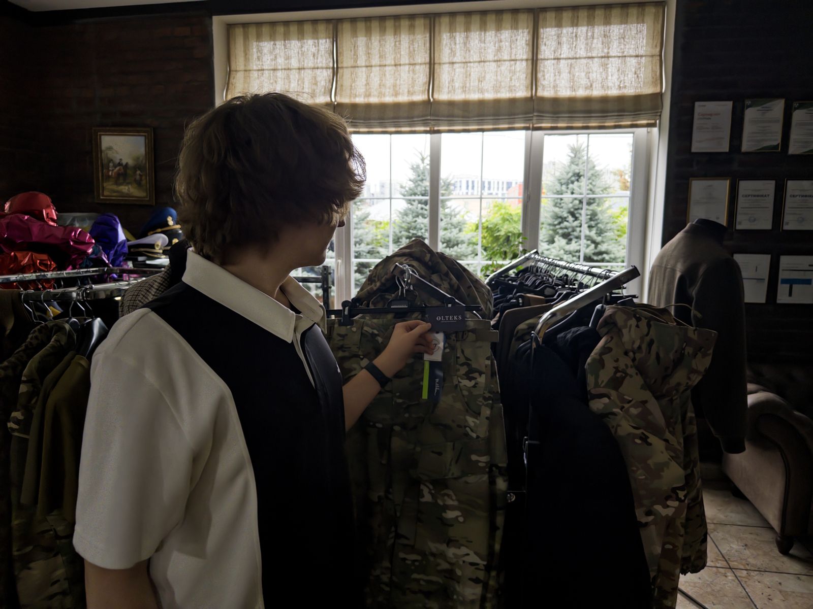 A SoilTwin team member looking at a tagged garment on a rail of finished Olteks clothing